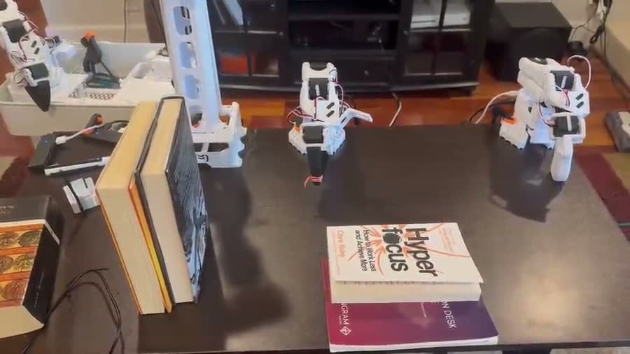 Robot arms picking up and stacking books on a table